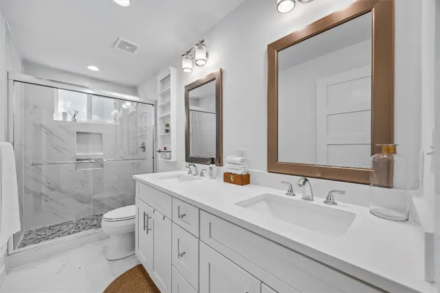 a bathroom with a sink a toilet and shower