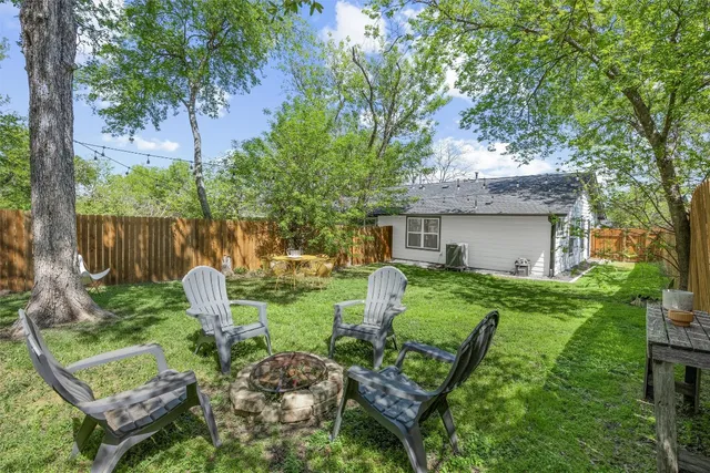 a view of backyard of house with outdoor seating and green space