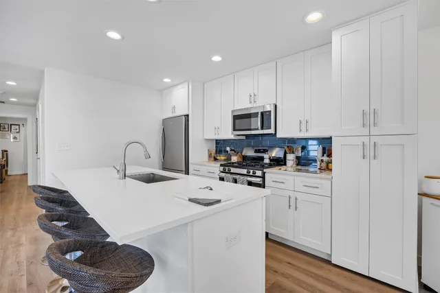 a kitchen with white cabinets and appliances