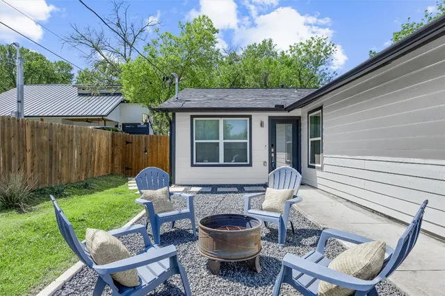 a view of a chair and table in backyard of the house