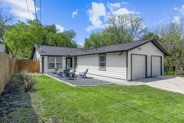 a view of backyard of house with outdoor seating and green space