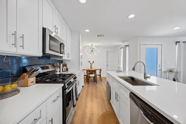 a kitchen with stainless steel appliances a stove sink and cabinets