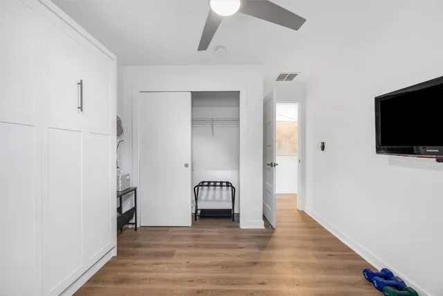 a view of a hallway with wooden floor and staircase