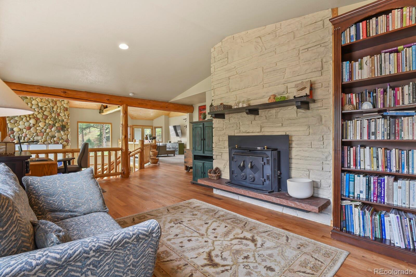 417 Witter Gulch Road Evergreen, CO 80439 - Photo 36 of 50 a living room with furniture and a fireplace