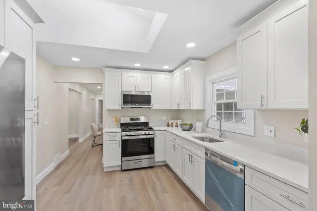 a kitchen with stainless steel appliances granite countertop a sink a stove a refrigerator and cabinets