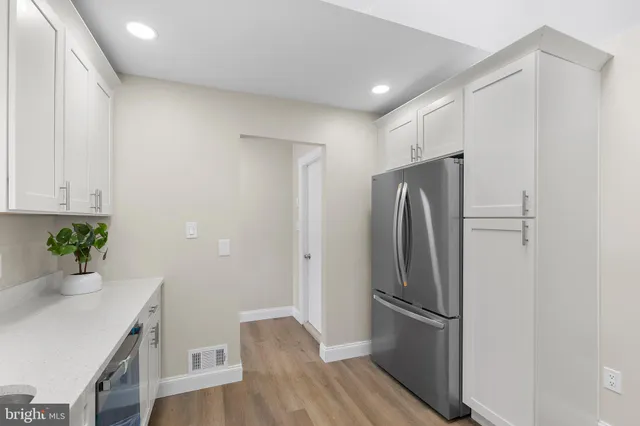 a kitchen with stainless steel appliances a refrigerator and wooden floor