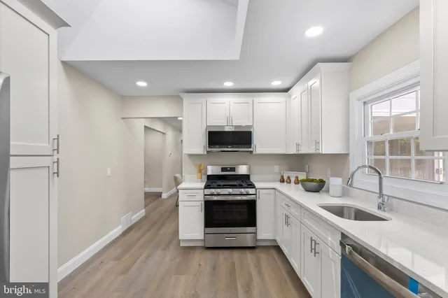 a kitchen with sink a microwave and cabinets