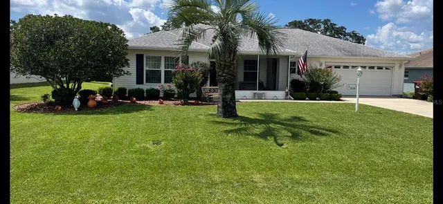 a view of a house with a yard and sitting area