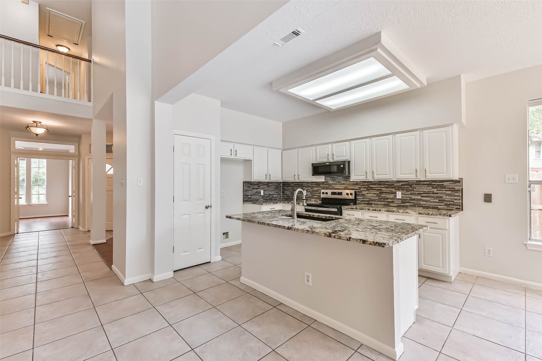 6338 Maple Spring Place Humble, TX 77346 - Photo 13 of 50 A kitchen designed to keep the cook part of the gathering. The central island provides a convenient place to prep and serve, while plentiful cabinetry helps keep everyday essentials organized and the open layout connects you to the surrounding living spaces.