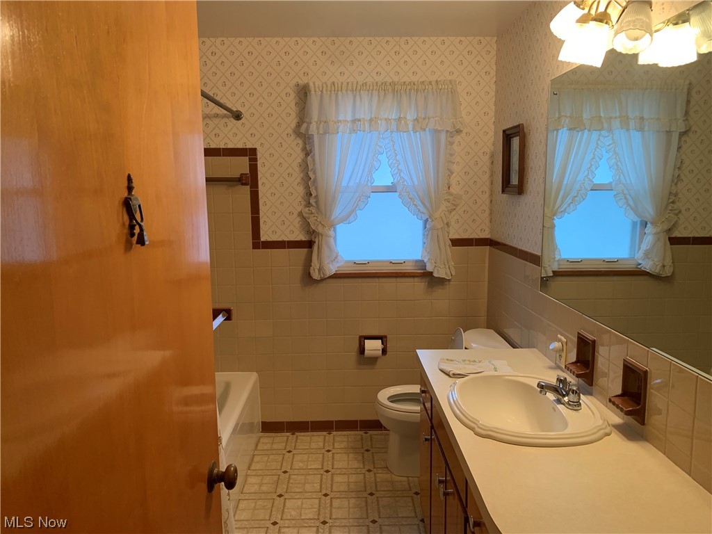 4530 8th Street Northwest Canton, OH 44708 - Photo 6 of 8 Bathroom featuring tile walls, toilet, a wealth of natural light, and large vanity