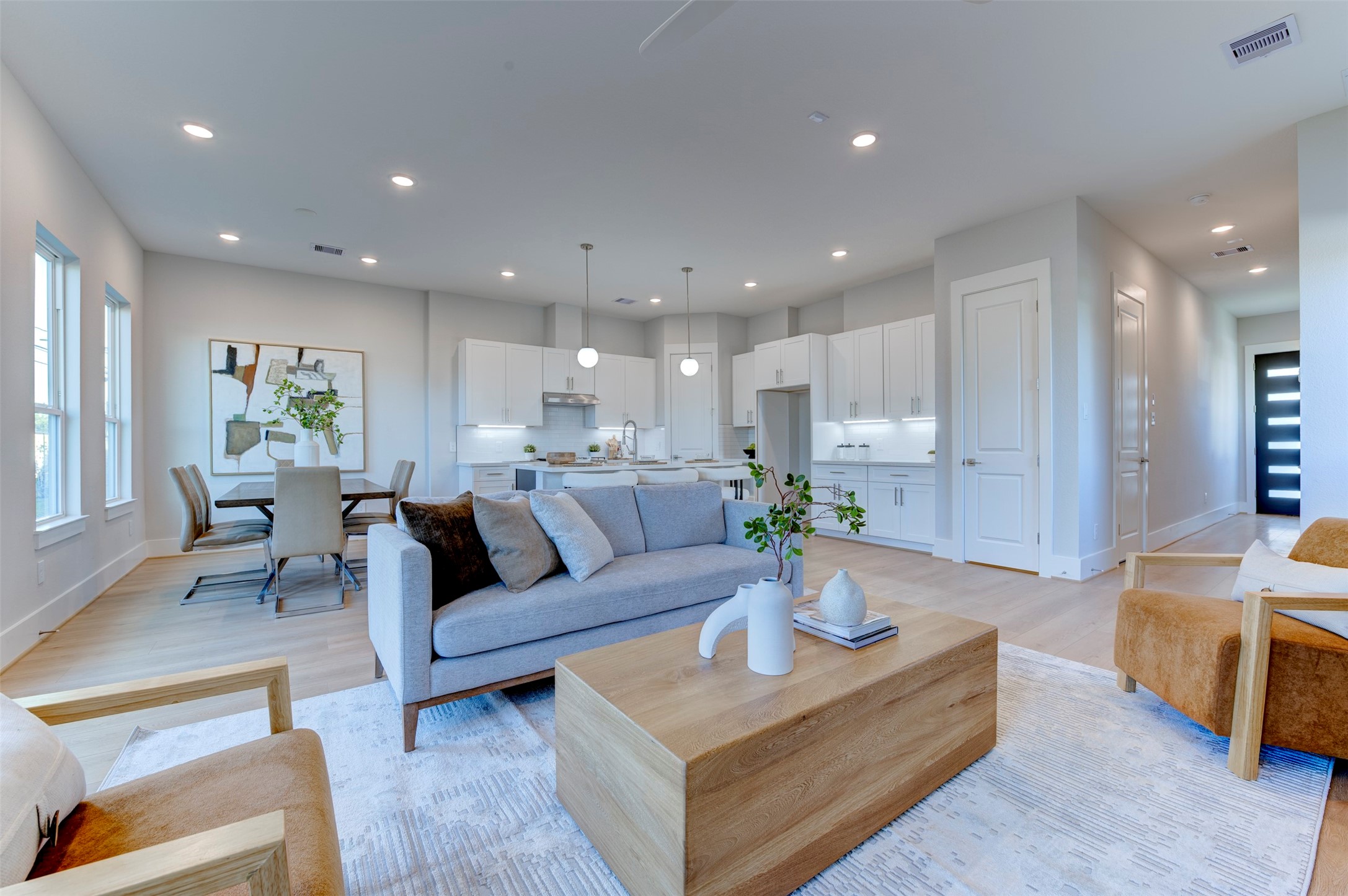 a living room with furniture and a dining table with kitchen view