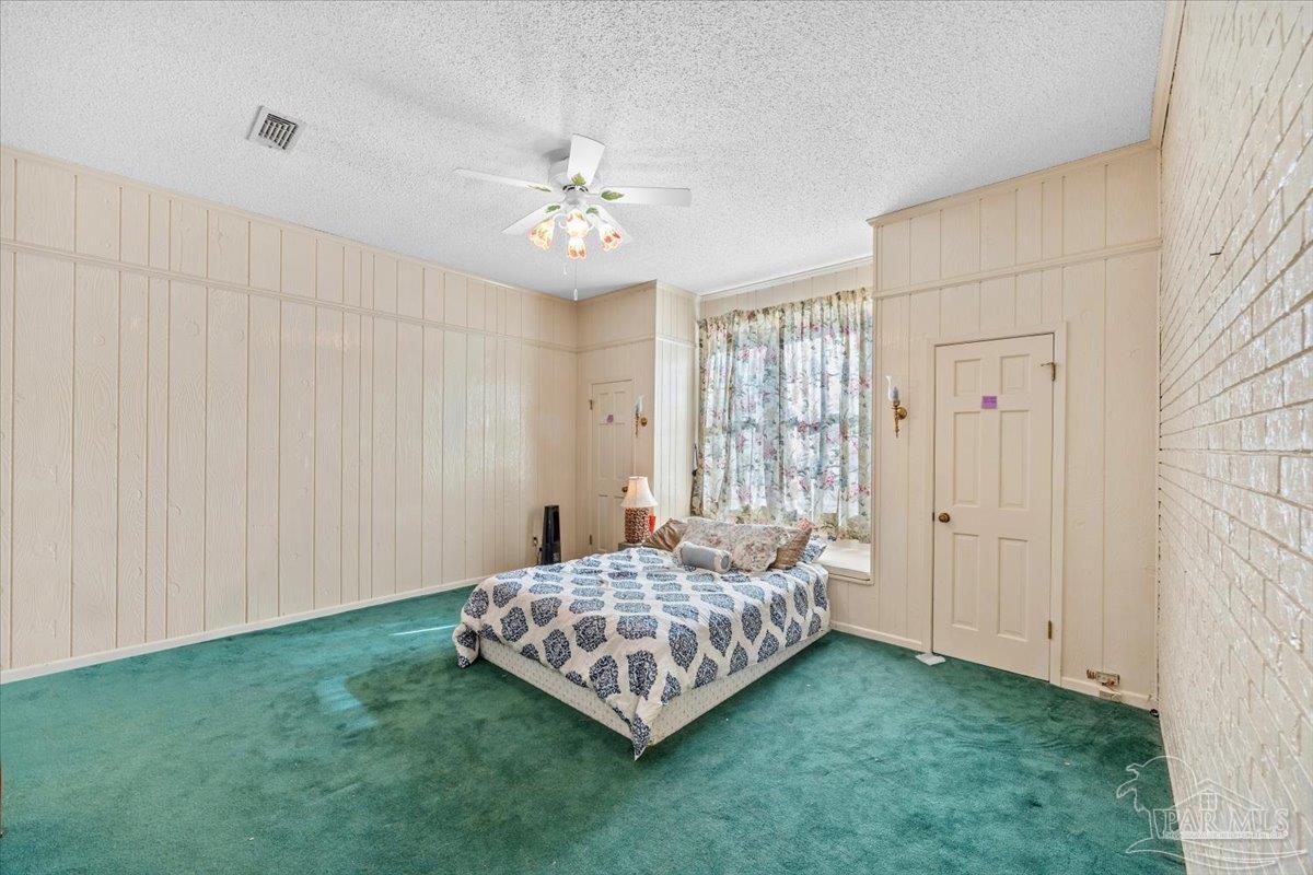 5560 Willard Norris Road Milton, FL 32570 - Photo 12 of 58 a room with a bed and a chandelier