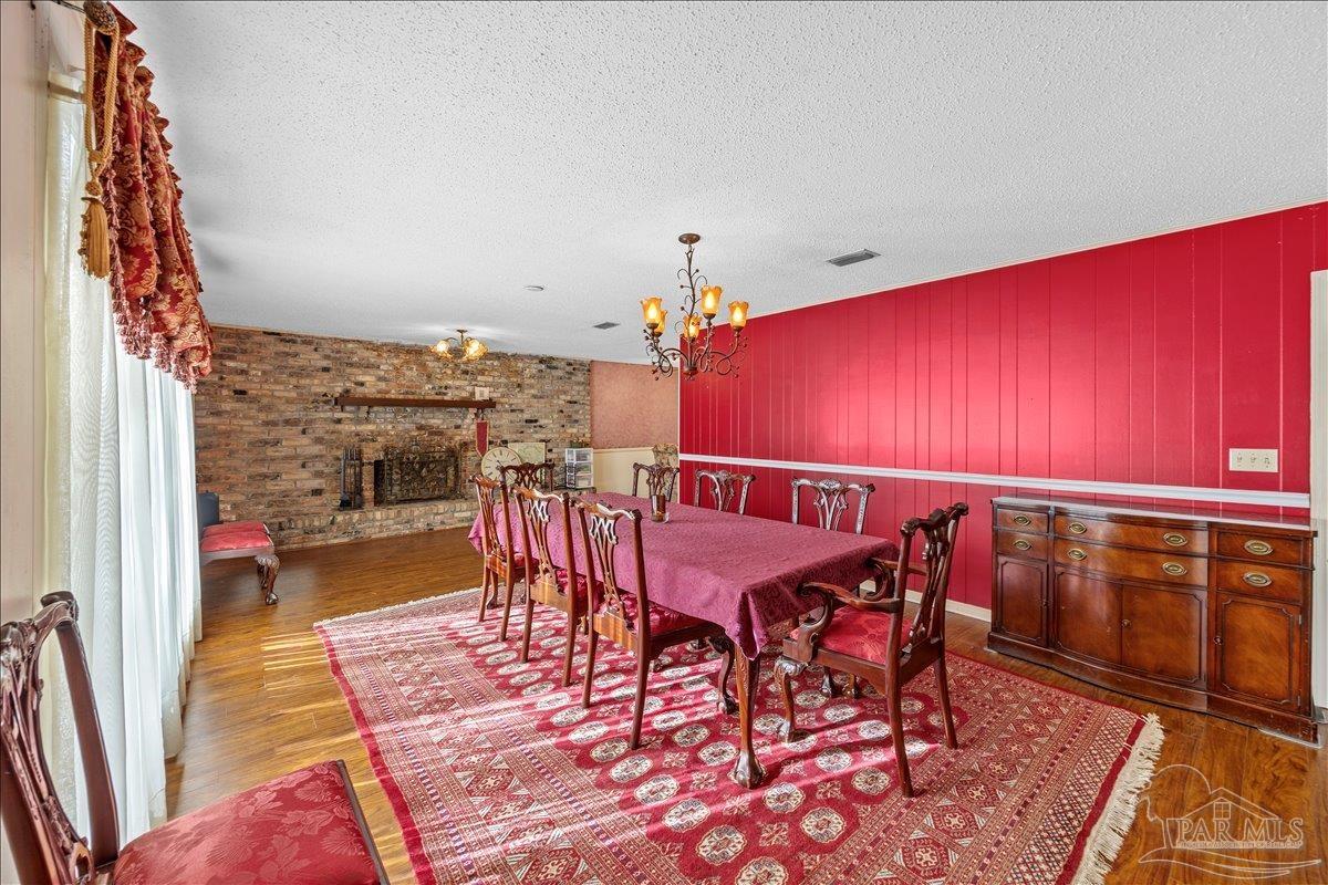 5560 Willard Norris Road Milton, FL 32570 - Photo 17 of 58 a dining room with furniture and wooden floor
