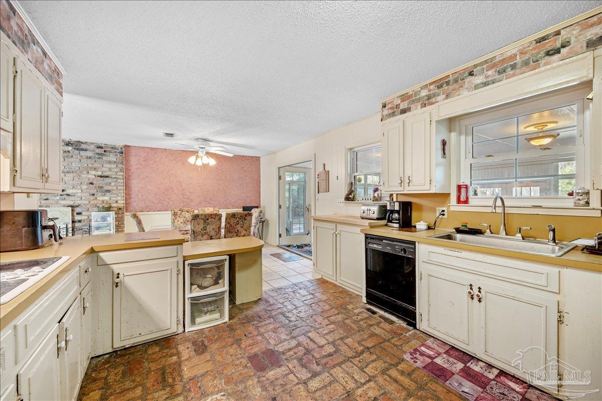 5560 Willard Norris Road Milton, FL 32570 - Photo 21 of 58 a kitchen with a sink stove and cabinets