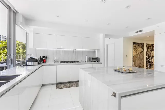 a kitchen with granite countertop a sink and white cabinets