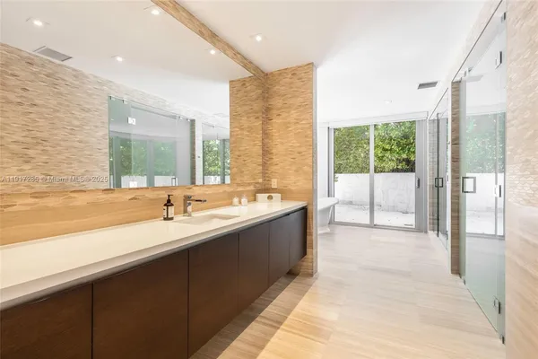 a large bathroom with a tub sink and mirror