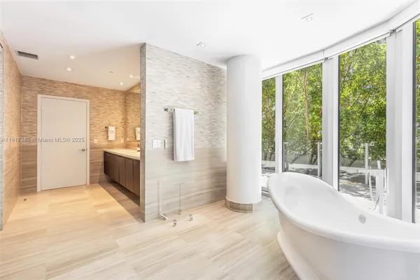 a bathroom with a tub sink and large window