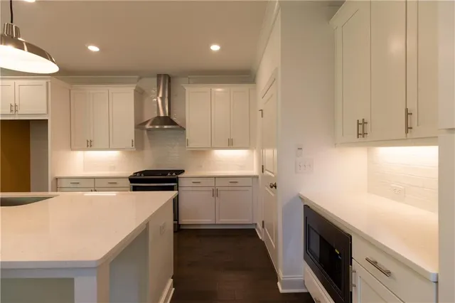 a kitchen with stainless steel appliances granite countertop a sink a stove and a refrigerator