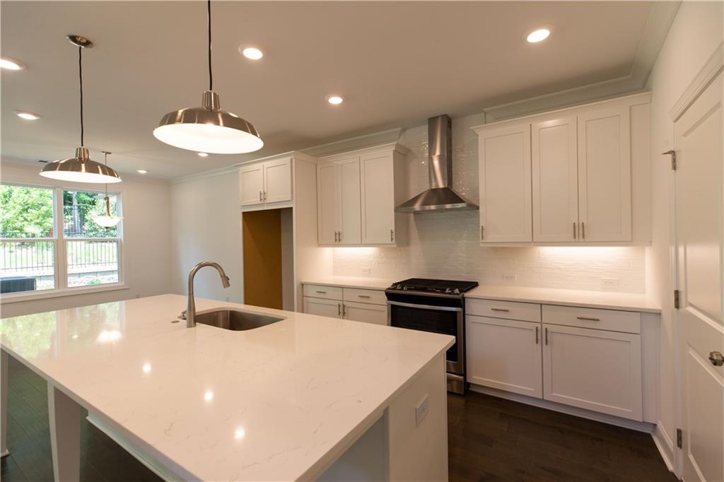 4912 Molder Avenue, Unit 66 Buford, GA 30518 - Photo 13 of 83 a kitchen with stainless steel appliances granite countertop a sink a stove a refrigerator and island with wooden floor