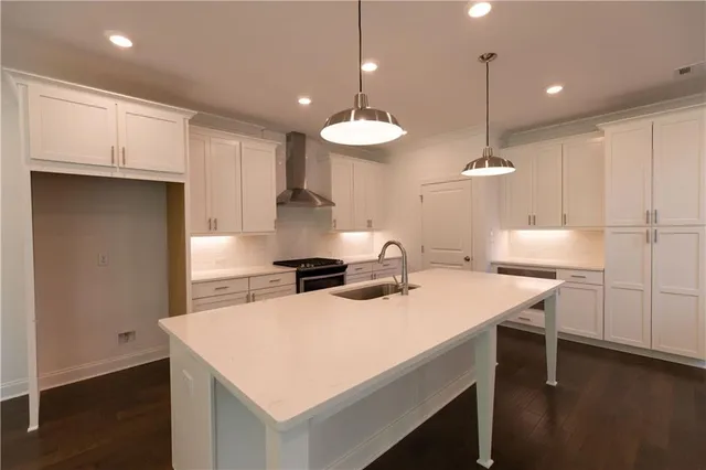a kitchen with white cabinets appliances and a sink