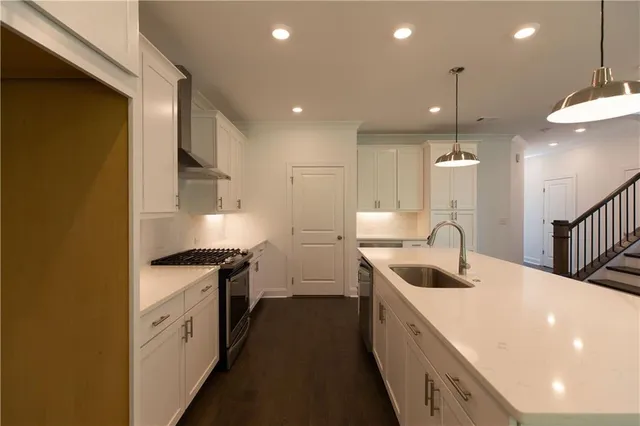 a kitchen with kitchen island a sink stainless steel appliances and refrigerator