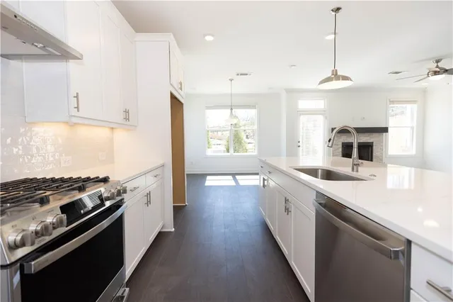 a view of an empty room with a window and a kitchen