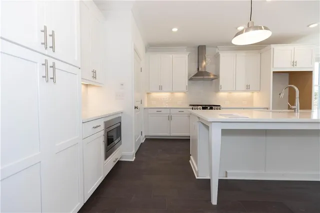 a view of a kitchen with a sink dishwasher a dining table and chairs with wooden floor
