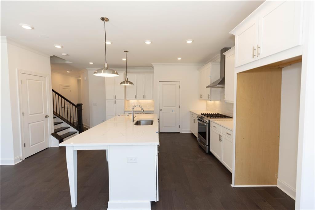 4912 Molder Avenue, Unit 66 Buford, GA 30518 - Photo 22 of 83 a kitchen with kitchen island a sink stainless steel appliances and refrigerator