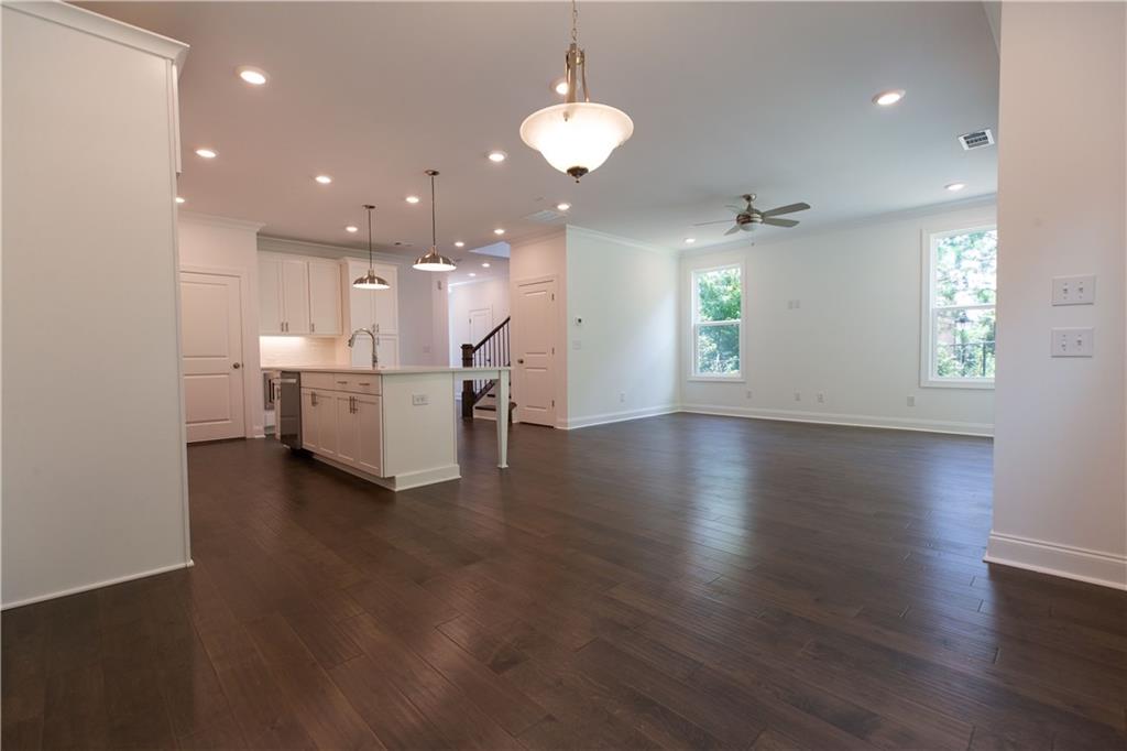4912 Molder Avenue, Unit 66 Buford, GA 30518 - Photo 26 of 83 a view of a kitchen with a sink dishwasher a dining table and chairs with wooden floor