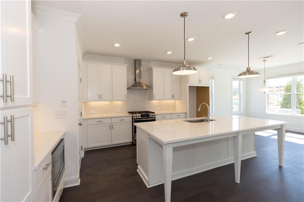 4912 Molder Avenue, Unit 66 Buford, GA 30518 - Photo 9 of 83 a kitchen with a stove a sink a center island and a wooden floor