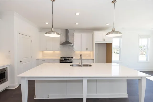 a kitchen with kitchen island a stove a center island a sink and a living room view