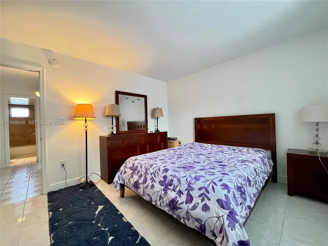 a bedroom with a large bed and a mirror