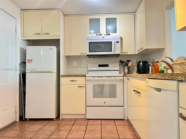 a kitchen with stainless steel appliances a refrigerator sink and cabinets