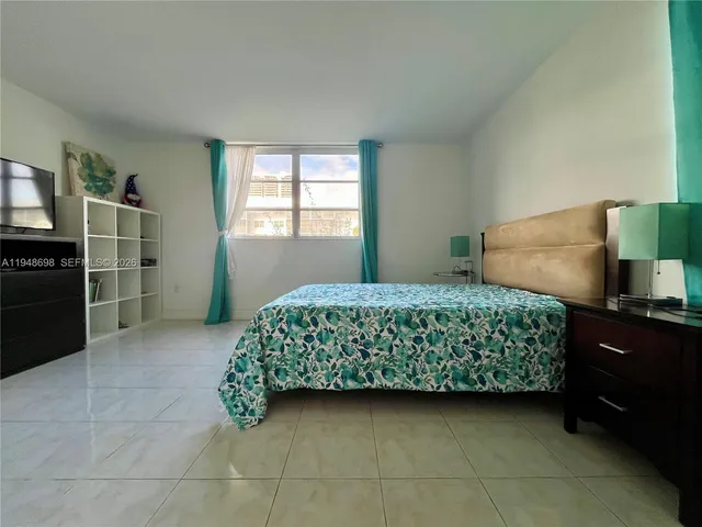 a bedroom with a bed and a tv on the dresser