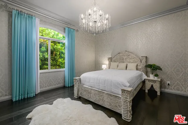 a spacious bedroom with a bed and a chandelier