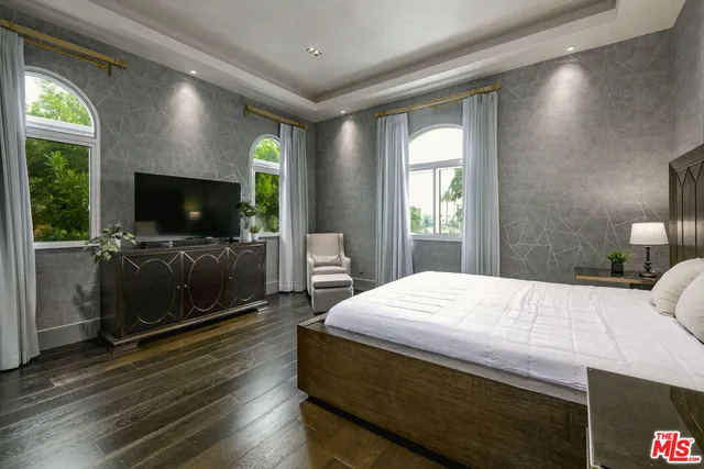 a bedroom with a bed and a flat screen tv