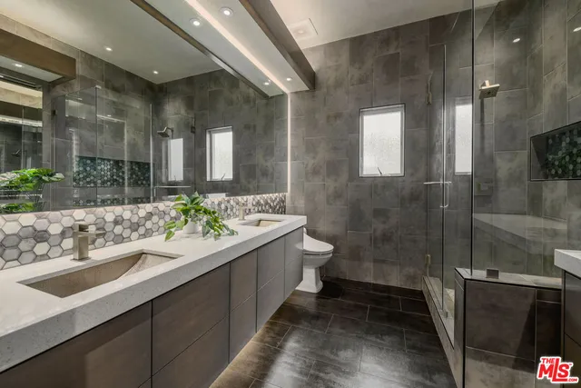a bathroom with a double vanity sink toilet and shower