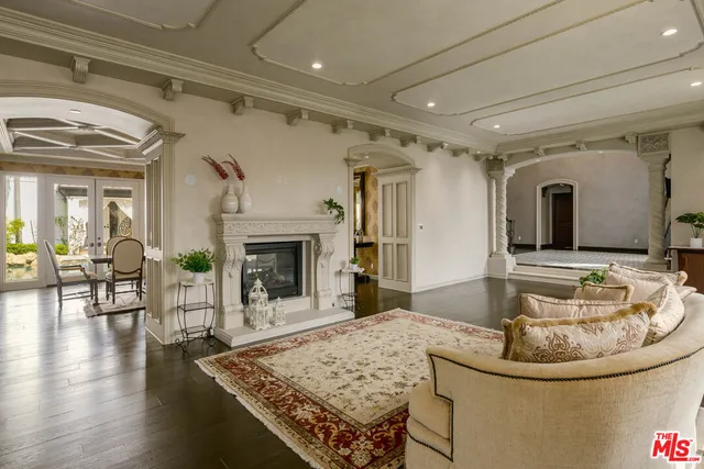 a living room with fireplace and dining table