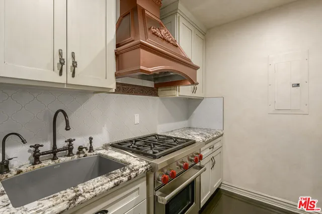 a stove top oven sitting inside of a kitchen