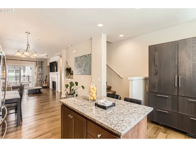 a kitchen with kitchen island granite countertop a sink and refrigerator