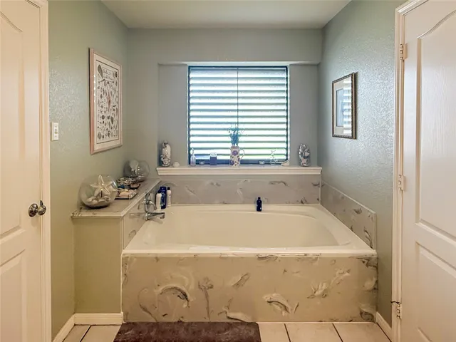 a bathroom with a tub sink and window