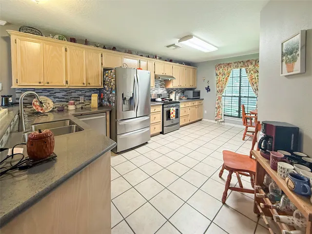 a kitchen with stainless steel appliances a refrigerator and a stove top oven