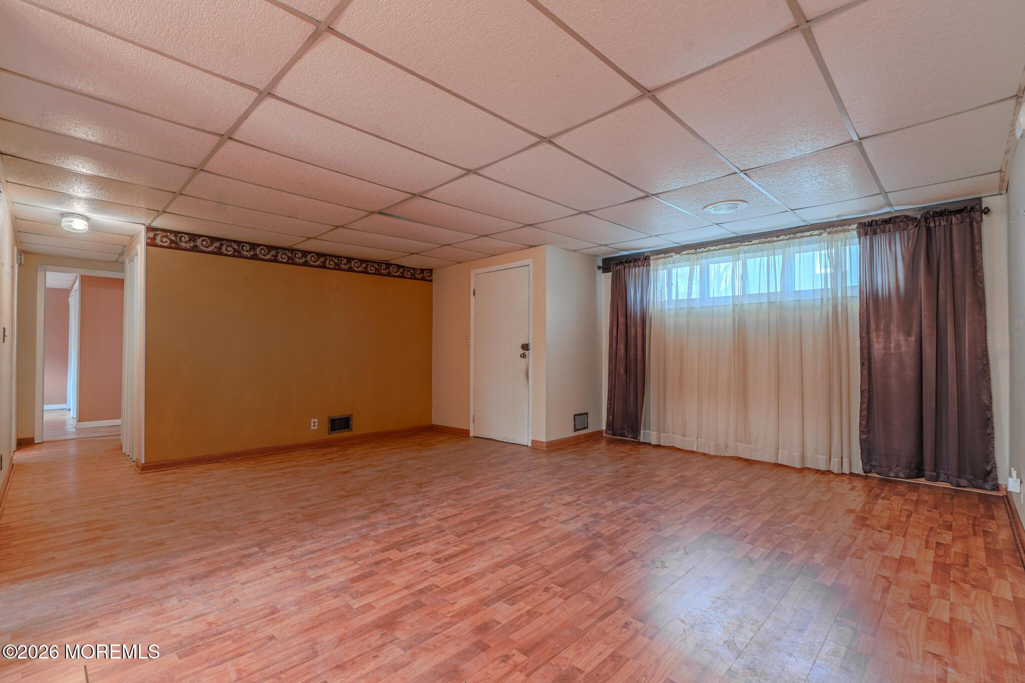 a view of empty room with wooden floor