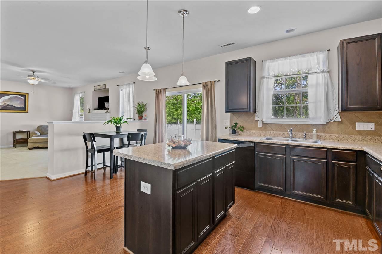 3239 Sunbright Lane Raleigh, NC 27610 - Photo 5 of 18 a kitchen with a stove a sink a dining table and chairs