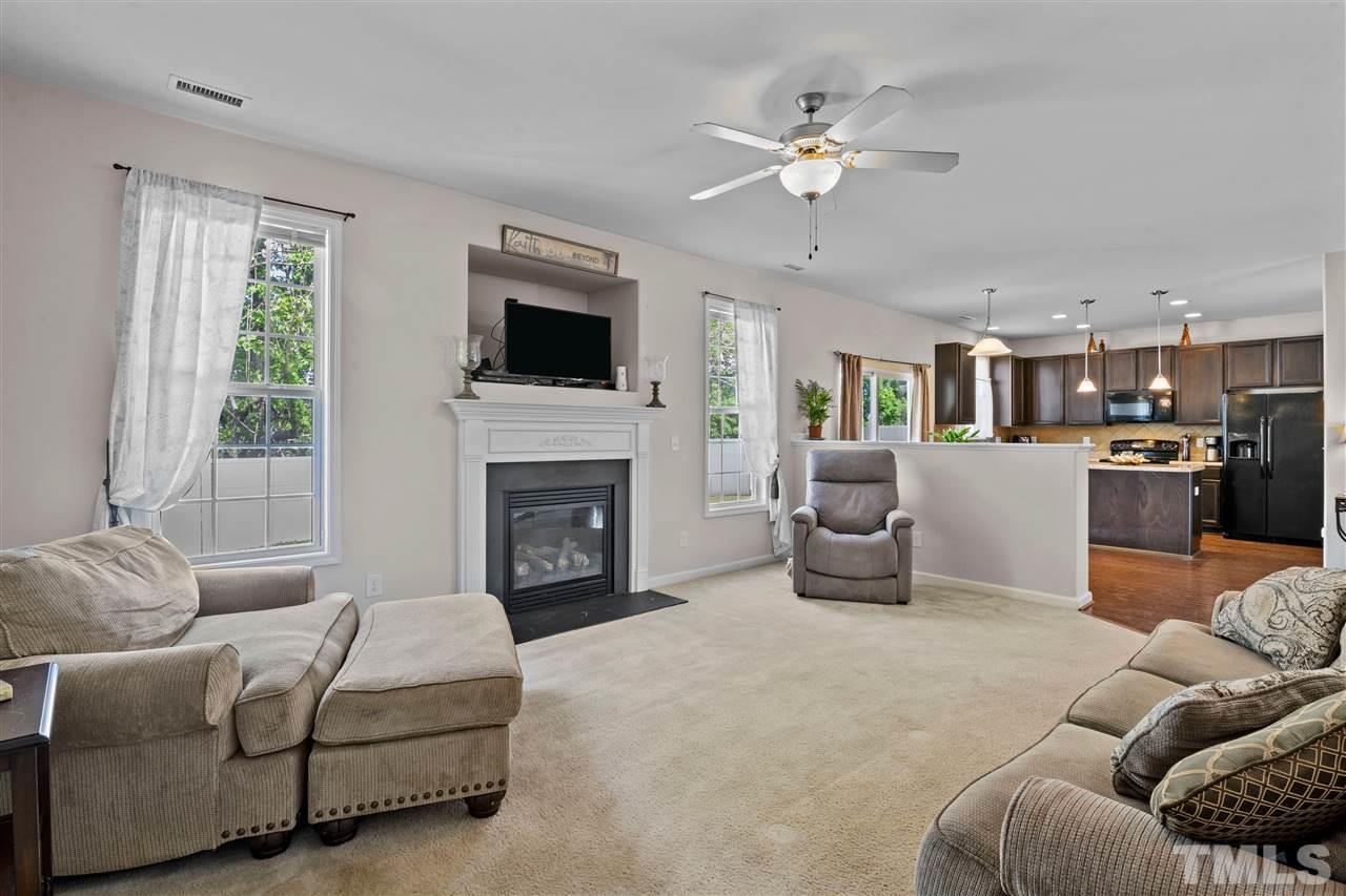 3239 Sunbright Lane Raleigh, NC 27610 - Photo 7 of 18 a living room with furniture fireplace and flat screen tv
