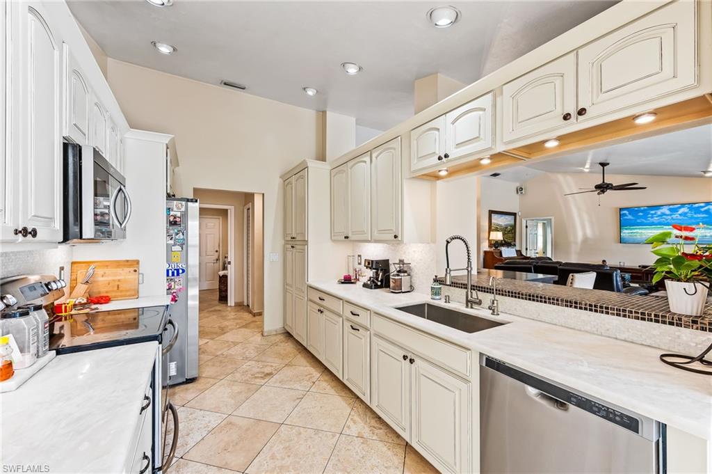 2271 Oakes Boulevard Naples, FL 34119 - Photo 15 of 47 a kitchen with stainless steel appliances kitchen island granite countertop a sink and cabinets