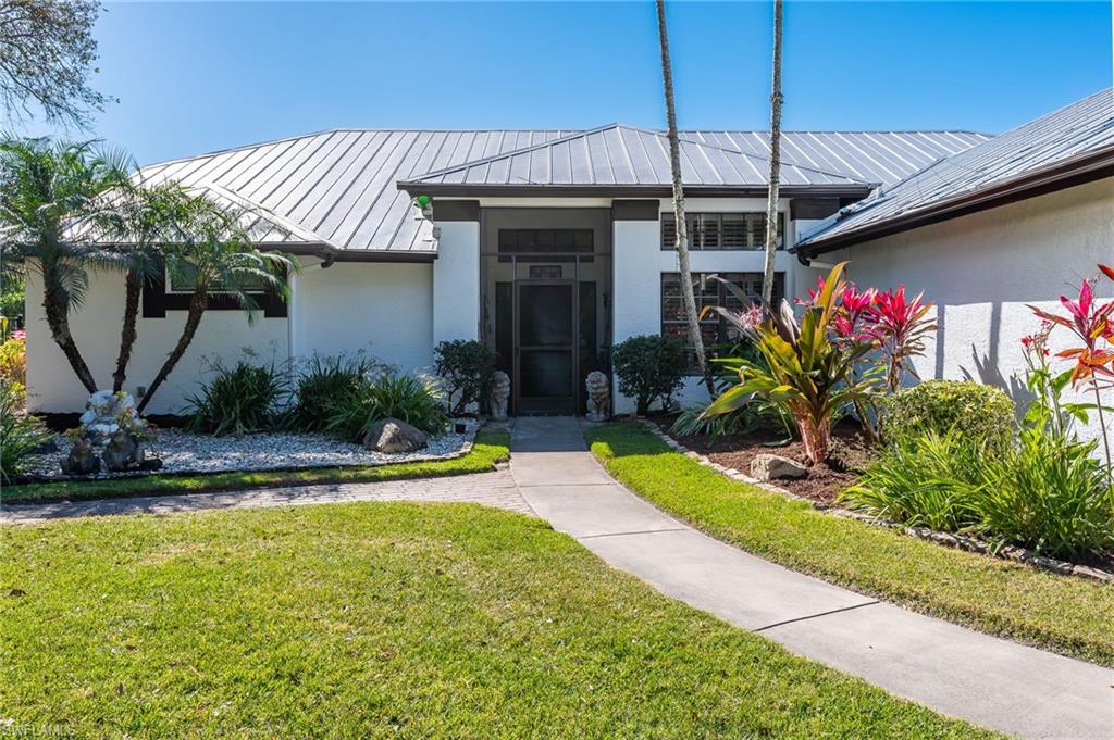 2271 Oakes Boulevard Naples, FL 34119 - Photo 2 of 47 a front view of a house with swimming pool