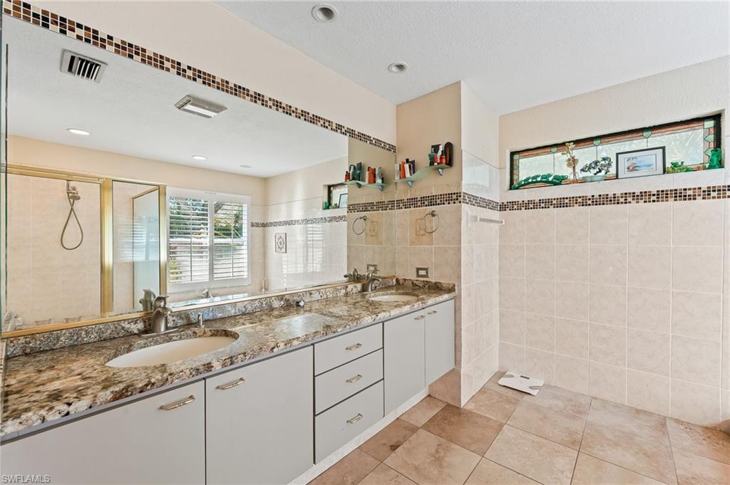 2271 Oakes Boulevard Naples, FL 34119 - Photo 26 of 47 a bathroom with a granite countertop sink and a mirror