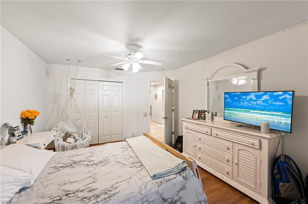 2271 Oakes Boulevard Naples, FL 34119 - Photo 34 of 47 a bedroom with a bed a chandelier and a dresser