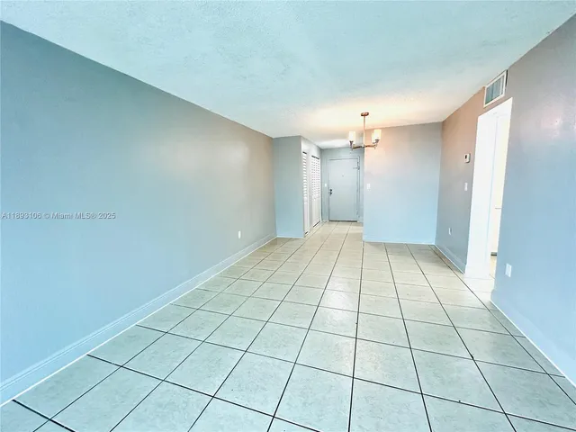 a view of a livingroom with an empty space and a window